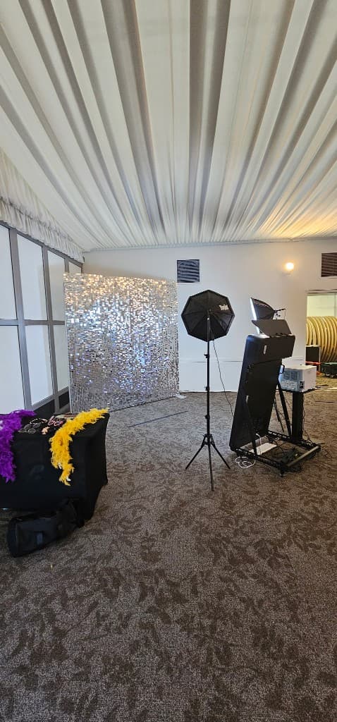 Photo booth setup with sequin backdrop, props, and professional lighting